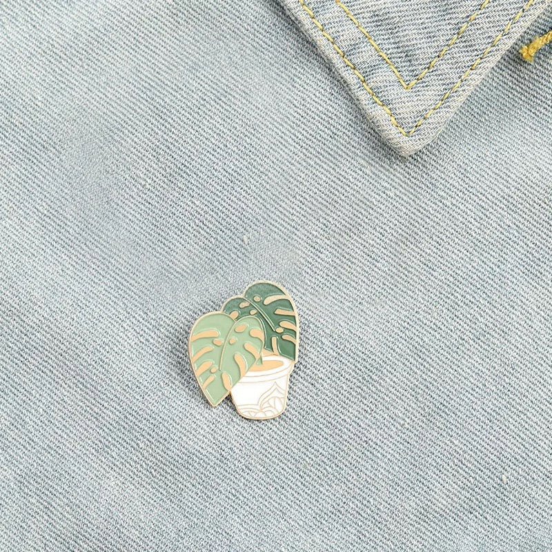 Goldene Monstera-Pflanze in einem Topf Button