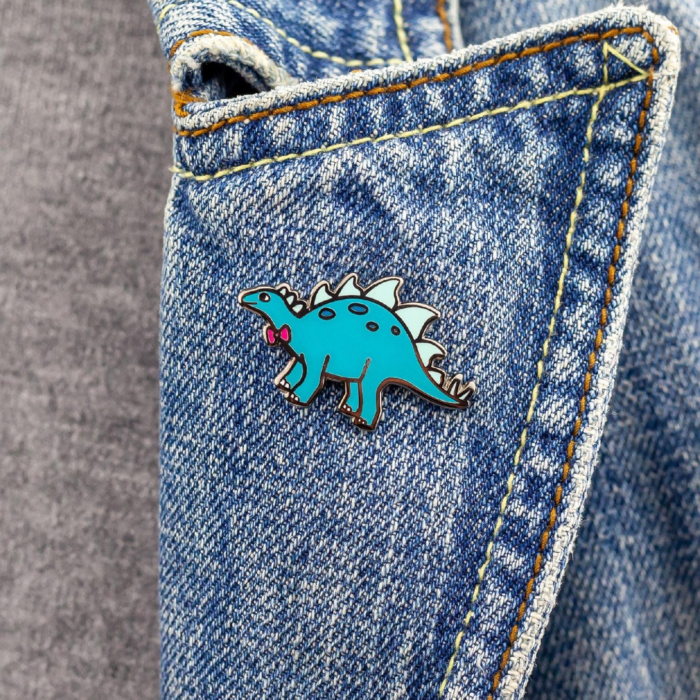 Türkisfarbener Dinosaurier mit Schleife - Anstecker für ein Kind