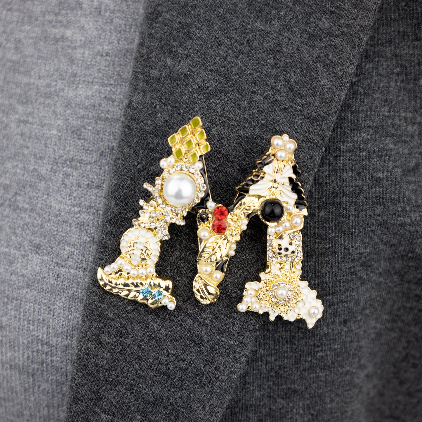 Goldbrosche mit dem Buchstaben M