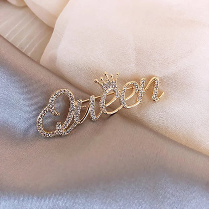 Goldinschrift „Queen“ mit einer Krone – Brosche mit Zirkonia