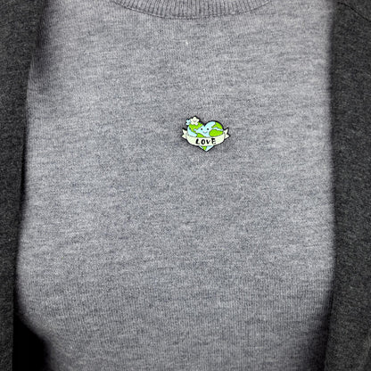 Umweltfreundlicher Pin mit einem Herz in Form des Planeten Erde und der Aufschrift „Love“