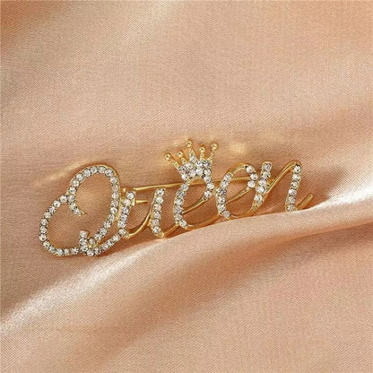Goldinschrift „Queen“ mit einer Krone – Brosche mit Zirkonia