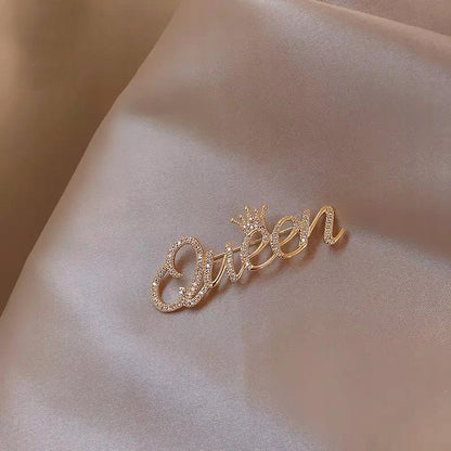 Goldinschrift „Queen“ mit einer Krone – Brosche mit Zirkonia